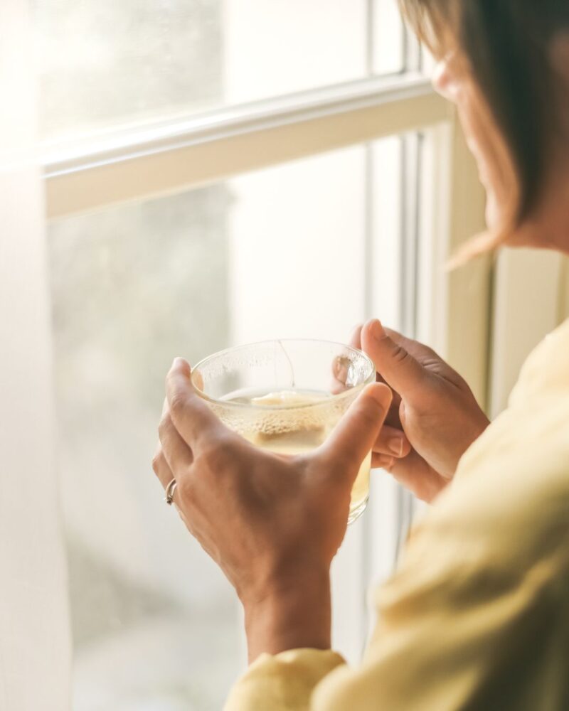 woman at window with cup of tea